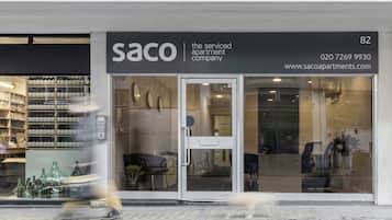 A storefront with the name 'SACO' and a contact number.