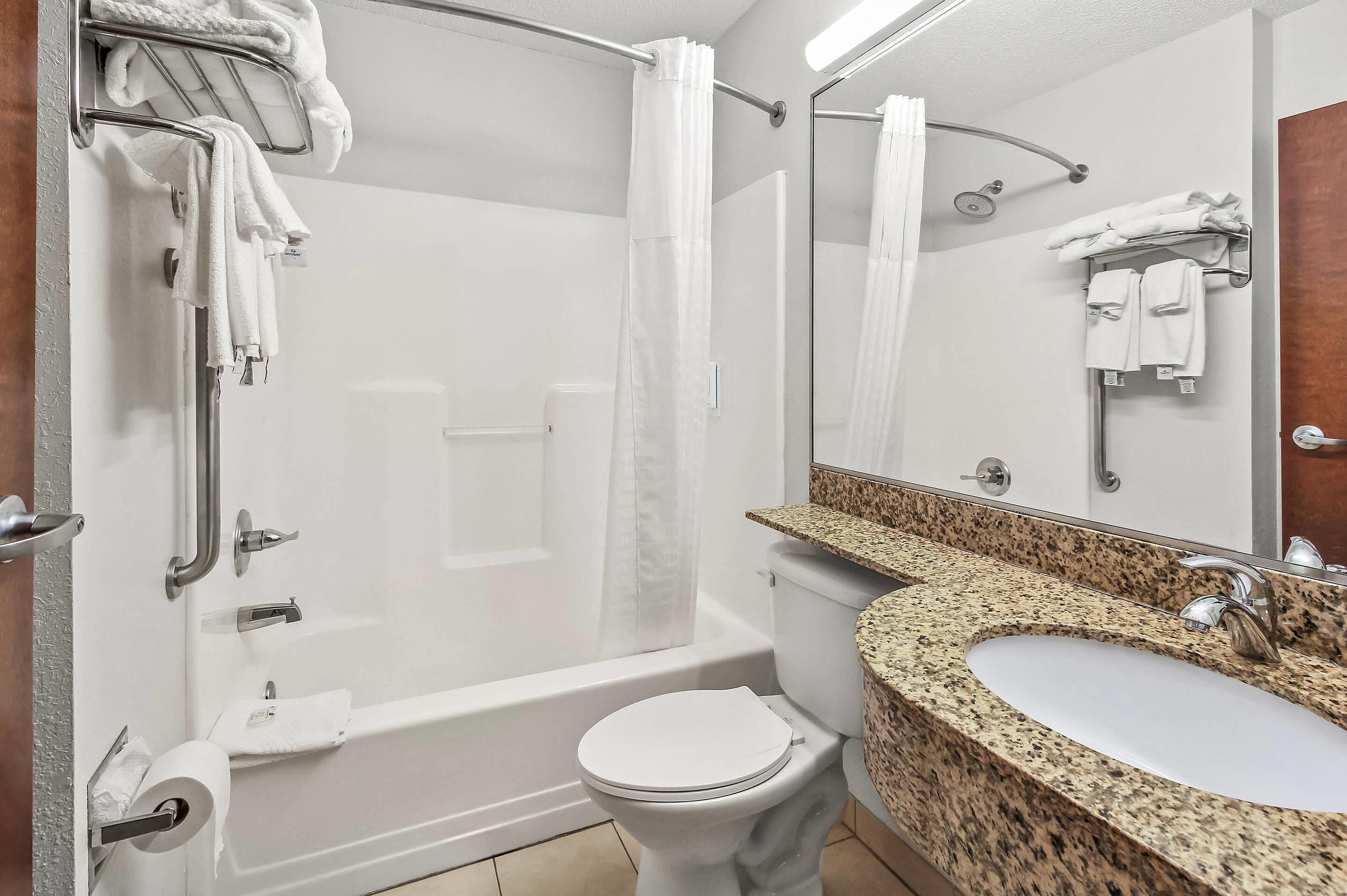 A modern bathroom with a shower, toilet, and sink.