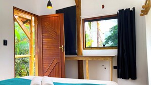 A room with a bed, a window, and a door leading to an outdoor area. - Hostel Sereia do Mar (Paraty)