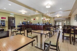 A spacious restaurant with multiple dining tables and chairs, a counter with various food and drink options, and a clean, well-lit interior. - Best Western Plus Moose Jaw (Moose Jaw)