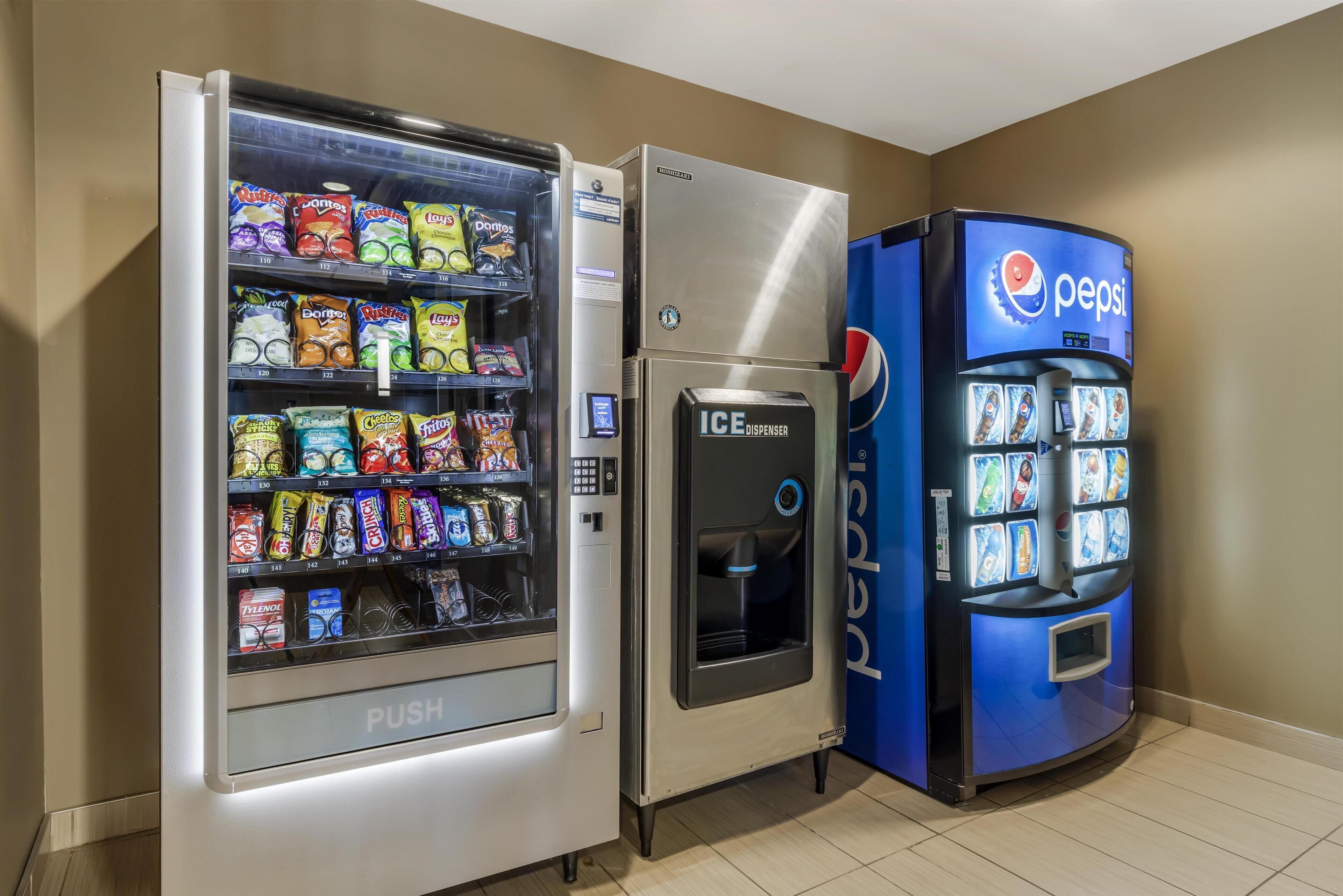 A vending machine with a Pepsi logo, a push vending machine with snacks, and an ice dispenser.