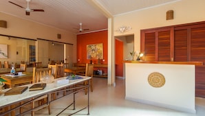 Una habitación amplia con zona de comedor, un espejo grande y un adorno mural.