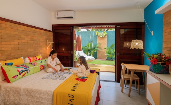 A bedroom with a bed, a desk, and a view of the garden. - Village Porto de Galinhas (Ipojuca)