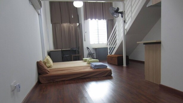 A compact room with a bed, a desk, and a staircase. - The CEO Duplex SOHO Suite (George Town)