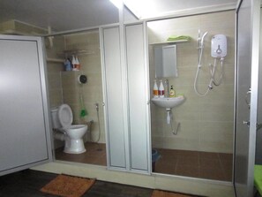 A bathroom with a toilet, shower, and sink. - The CEO Duplex SOHO Suite (George Town)