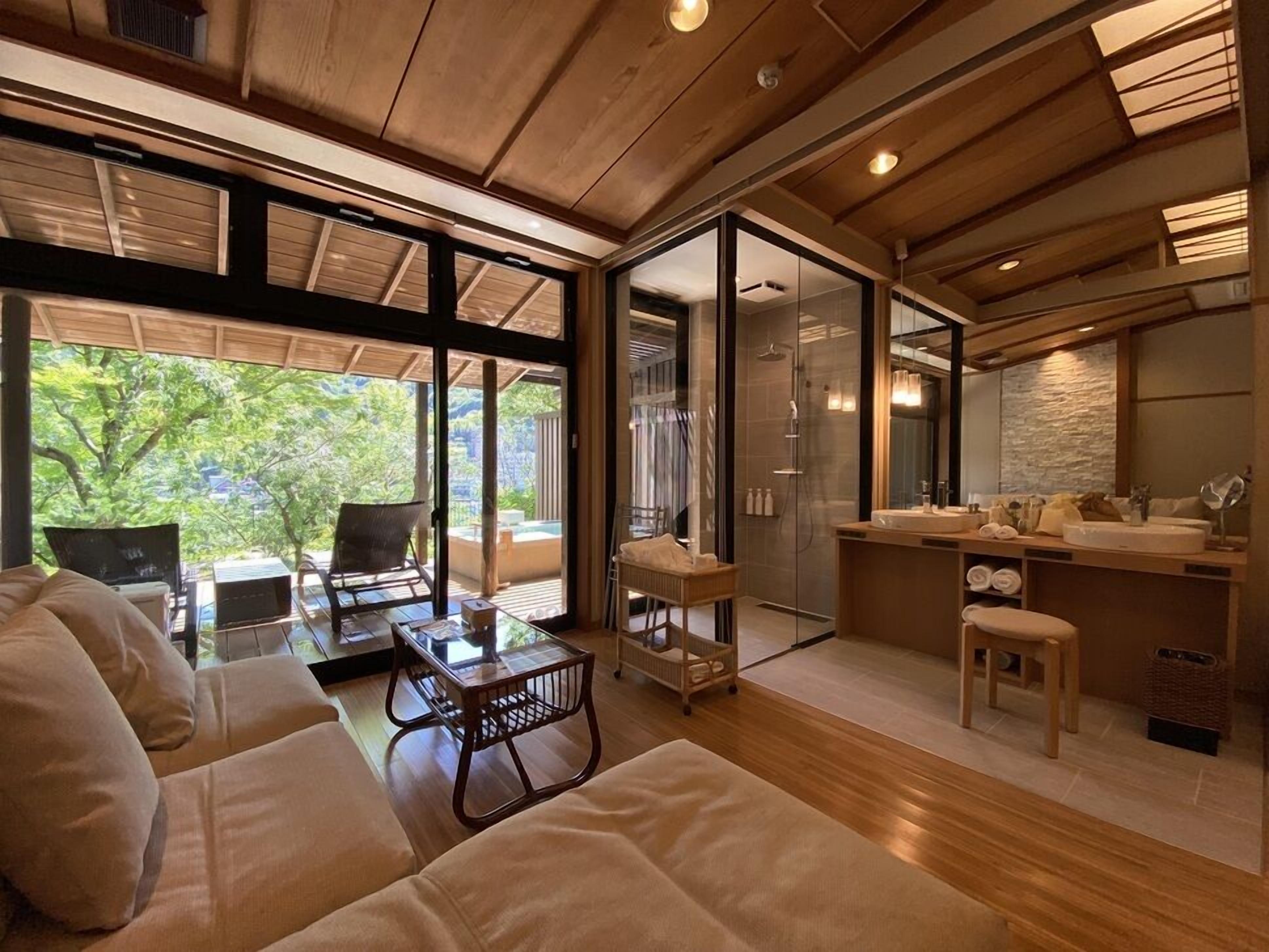 A modern interior with a sofa, a glass-enclosed shower, and a kitchen area.
