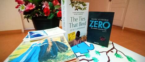 A table with books, a potted plant, and a puzzle.