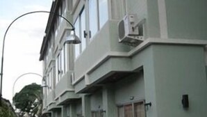 A row of townhouses with a narrow street, each with a front door and a small porch. - CS Park (Koh Samui)