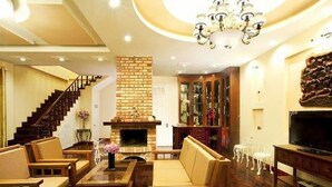 A spacious living room with a fireplace, comfortable seating, a staircase, and a television. - Terrasse Des Roses (Lang Biang - Da Lat)