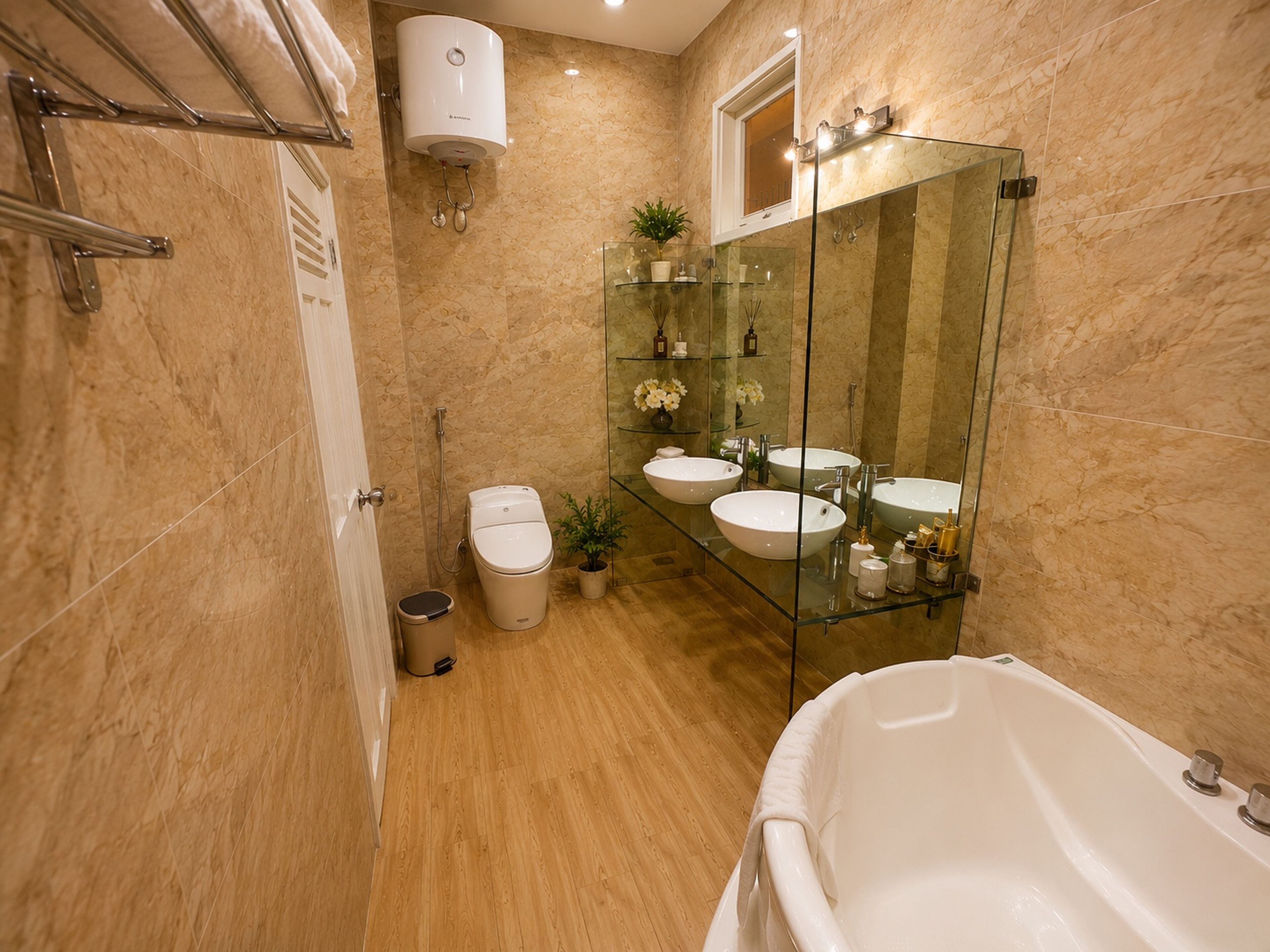 A modern bathroom with a glass-enclosed shower, a bathtub, and two sinks.
