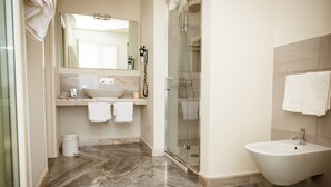 Ein Badezimmer mit Marmorboden, Waschbecken, Bidet und einer Duschkabine.
