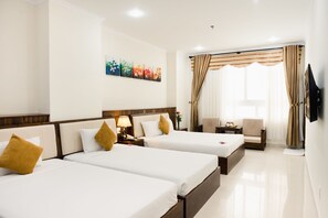 A hotel room with two beds, a TV, a chair, and a window with curtains.
