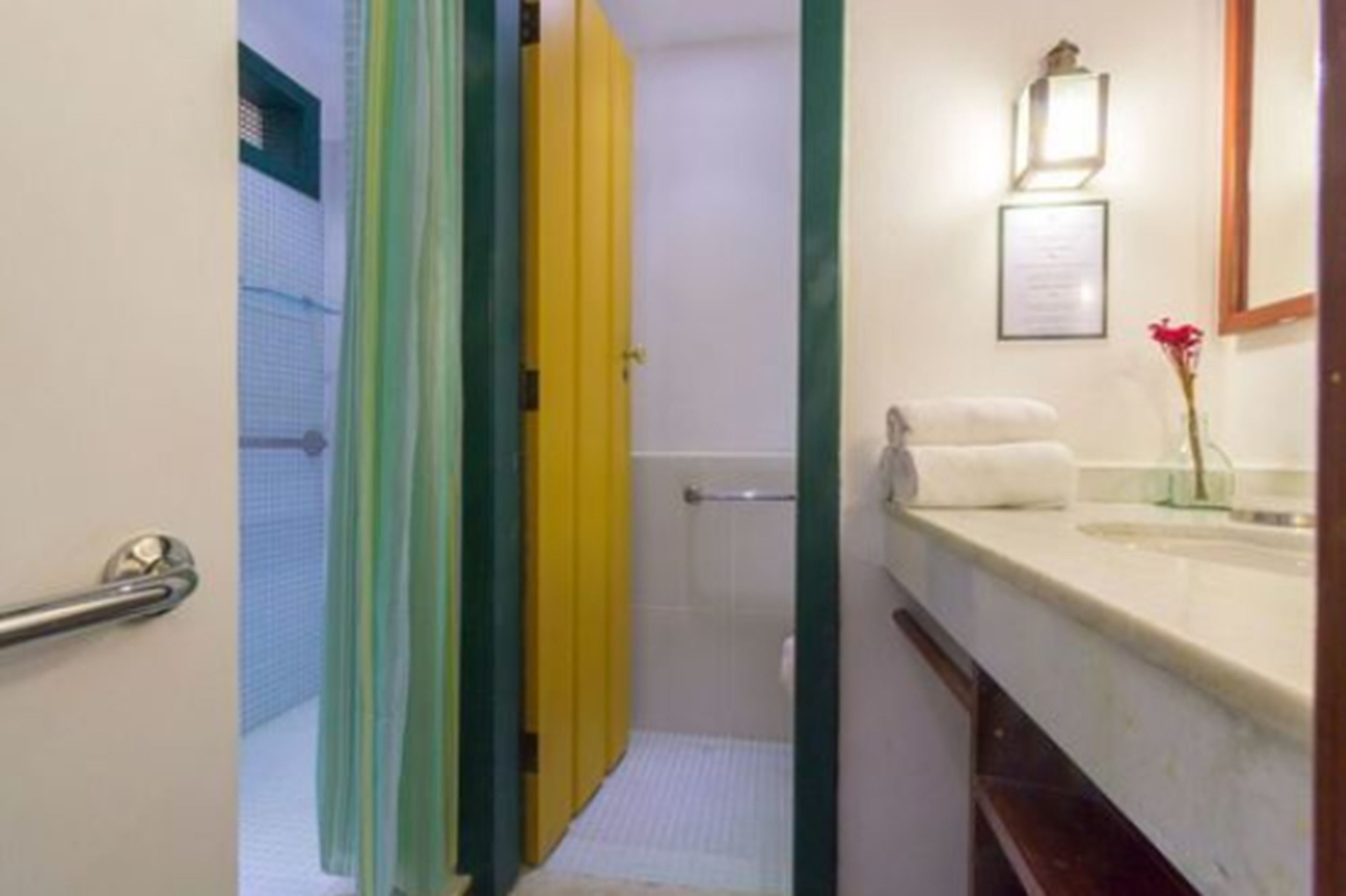 Um banheiro com chuveiro, porta-toalhas e um certificado emoldurado na parede.
