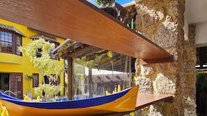 Un modelo de barco de madera, un muro de piedra y un edificio amarillo con ventanas.