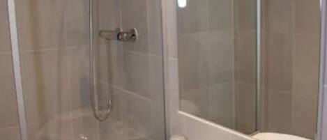 A modern bathroom with a glass-enclosed shower, a white sink, and a large mirror.