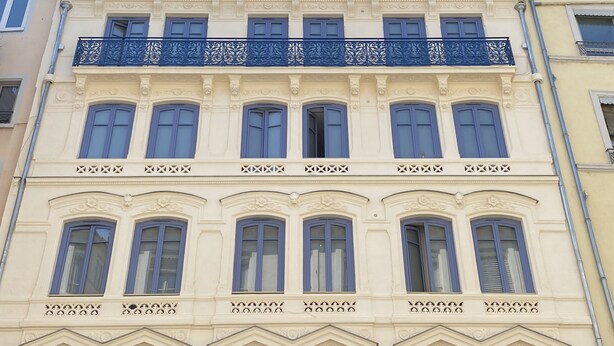 A multi-story building with ornate architectural details, including decorative balconies and window frames. - Hôtel de Paris (Lyon)