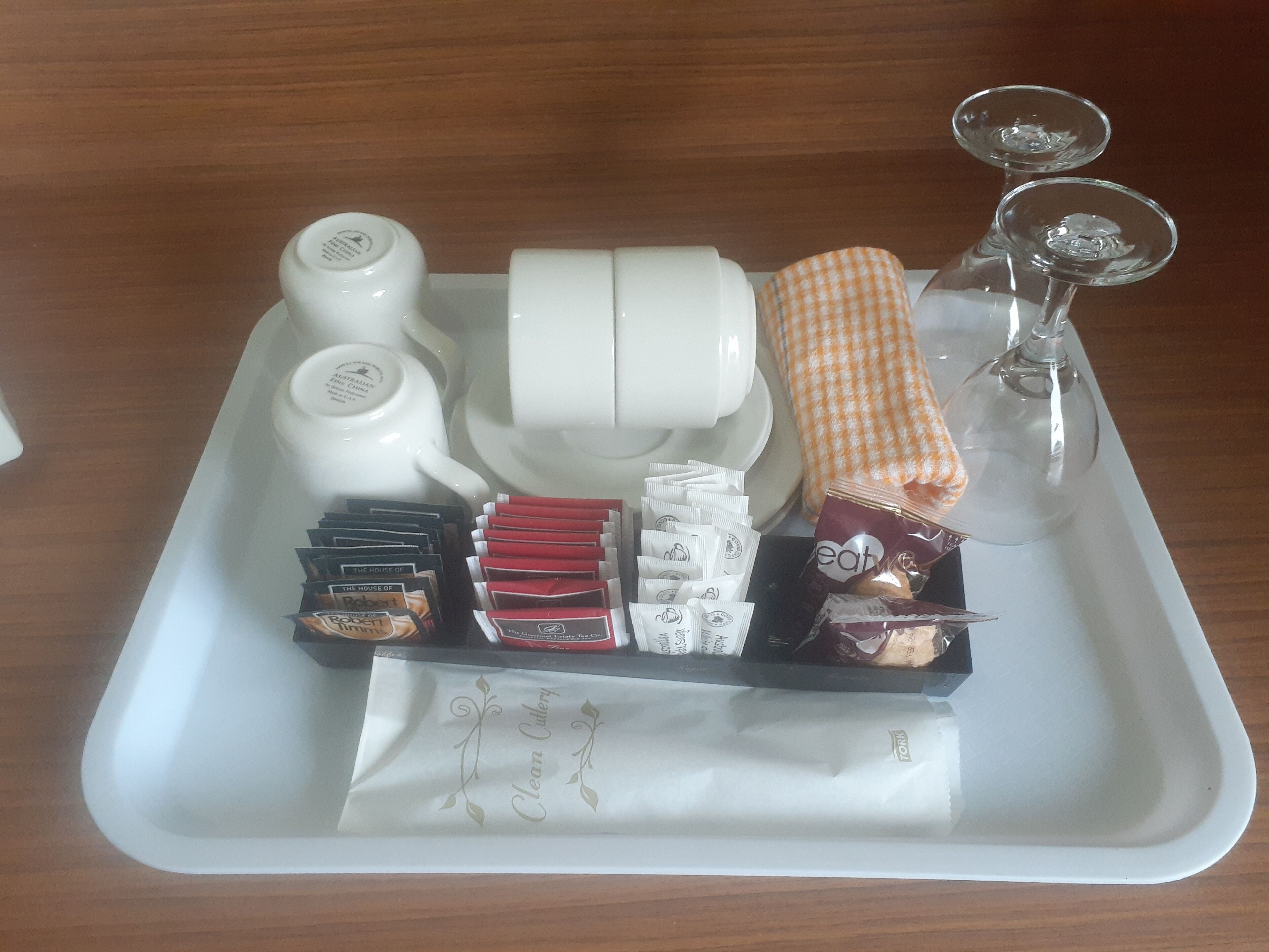 A tray with tea sets, books, and packaged snacks.