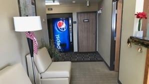 Un pasillo de hotel con un cartel de Pepsi, una recepción y una decoración navideña.