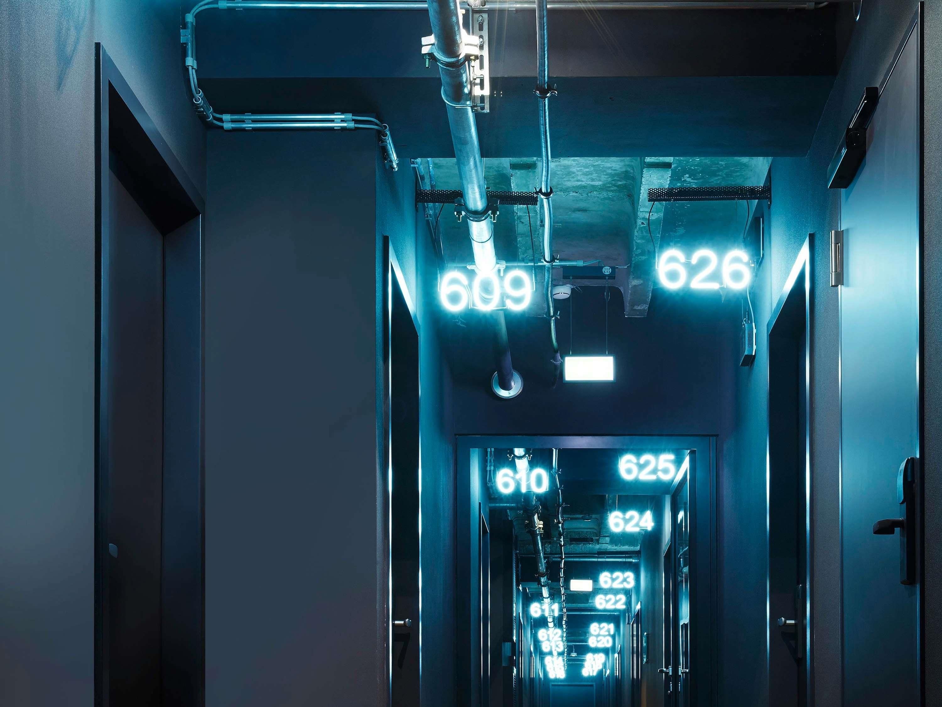 A hallway with illuminated numbers indicating room numbers, suggesting a hotel or similar accommodation.