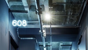 A modern, industrial-style hallway with illuminated numbers indicating room locations. - 25hours Hotel Bikini Berlin (Berlin)