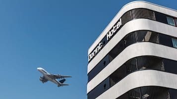 Edifício moderno de hotel com fachada curva e o nome "Dorint Hotel" visível.