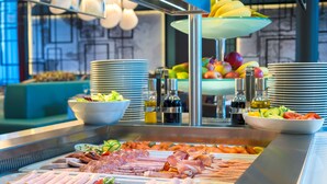 Un bufé con diversos alimentos, incluyendo carnes, quesos y frutas.