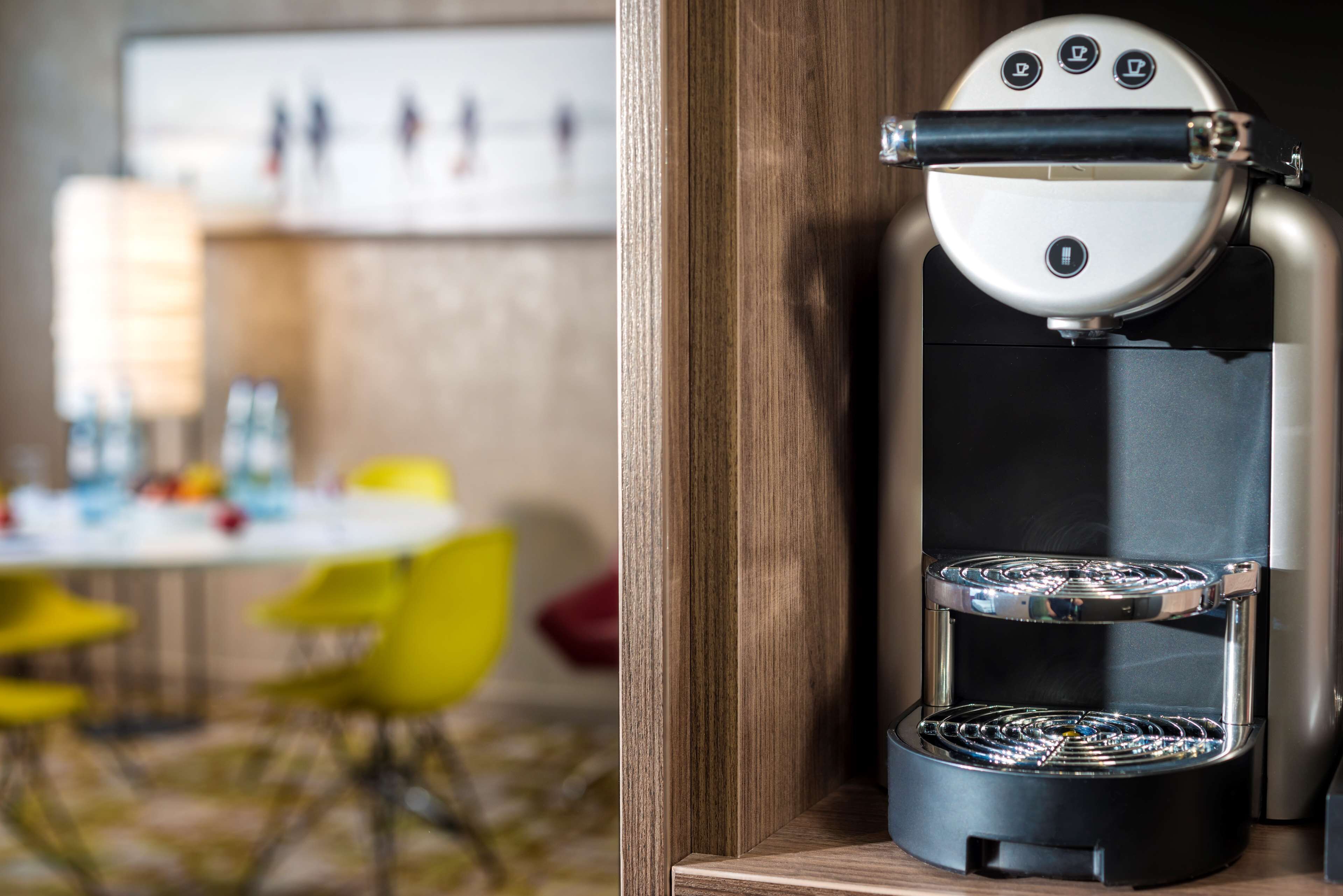Una cafetera moderna con panel de control y sistema de preparación de dos niveles.
