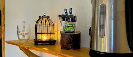 A shelf with a lantern, a coffee maker, and a cup.