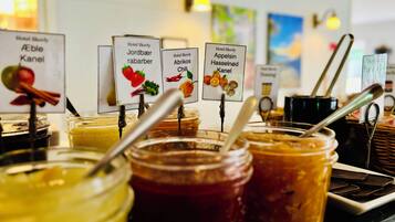Variedad de frascos con etiquetas que indican diferentes conservas y salsas, como manzana, fresa y chile.