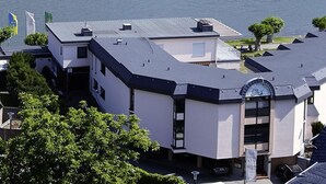 A modern building with a flat roof, large windows, and a visible clock. - Hotel Villa Am Rhein (Andernach)