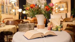Un libro abierto sobre una mesa con un florero y un candelabro.