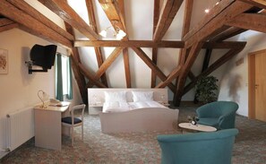 A bedroom with a bed, a desk, a chair, and a small table with glasses. - Hotel zur Krone (Beilngries)