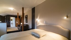 A hotel room with a large bed, a wooden headboard, a mirror, and a nightstand. - Thermen Hotel Bad Soden am Taunus (Bad Soden am Taunus)
