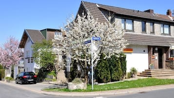 A residential street with houses, a car, and a street sign.
