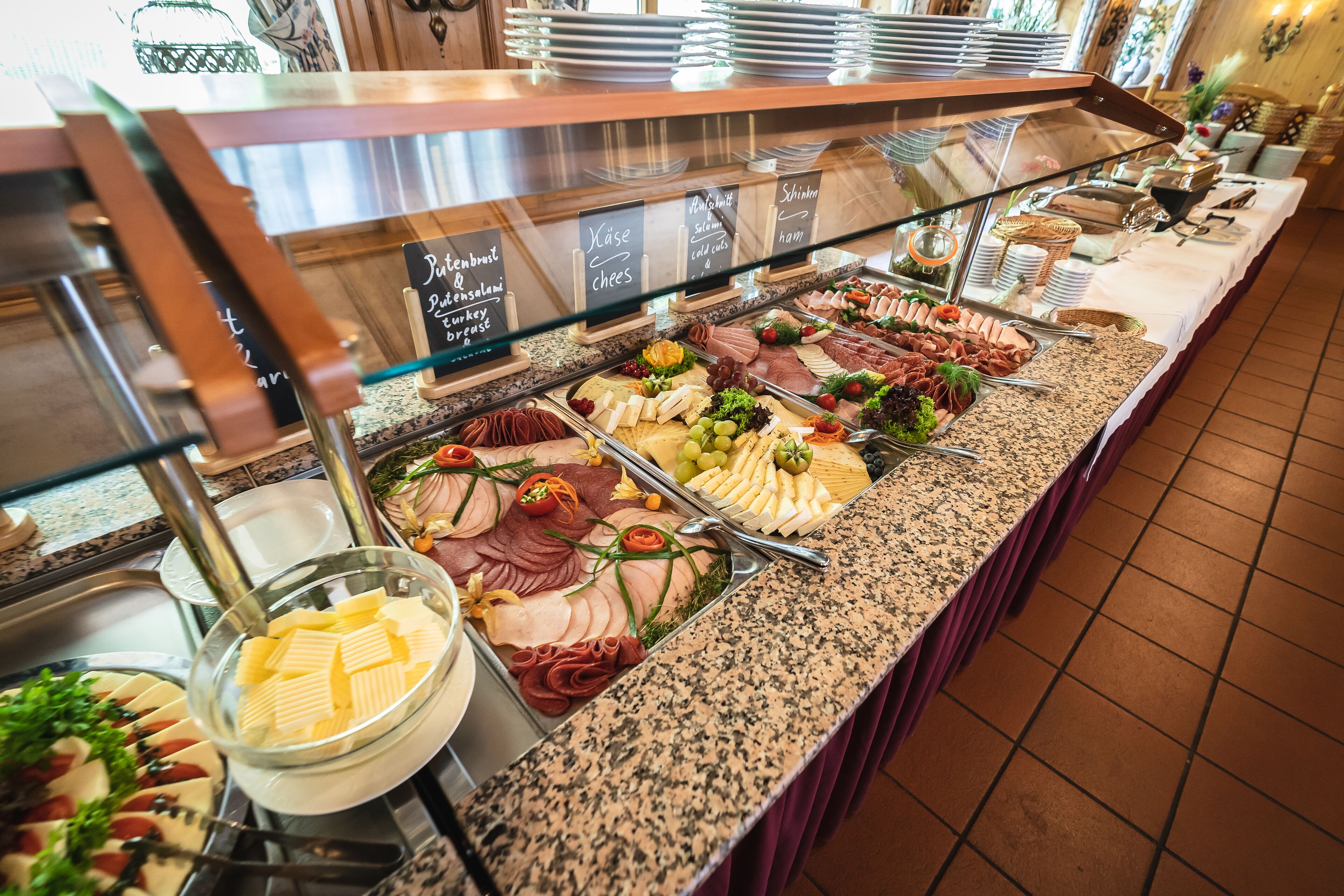 Ein reichhaltiges Buffet mit verschiedenen Speisen, darunter Fleisch, Käse und Obst.
