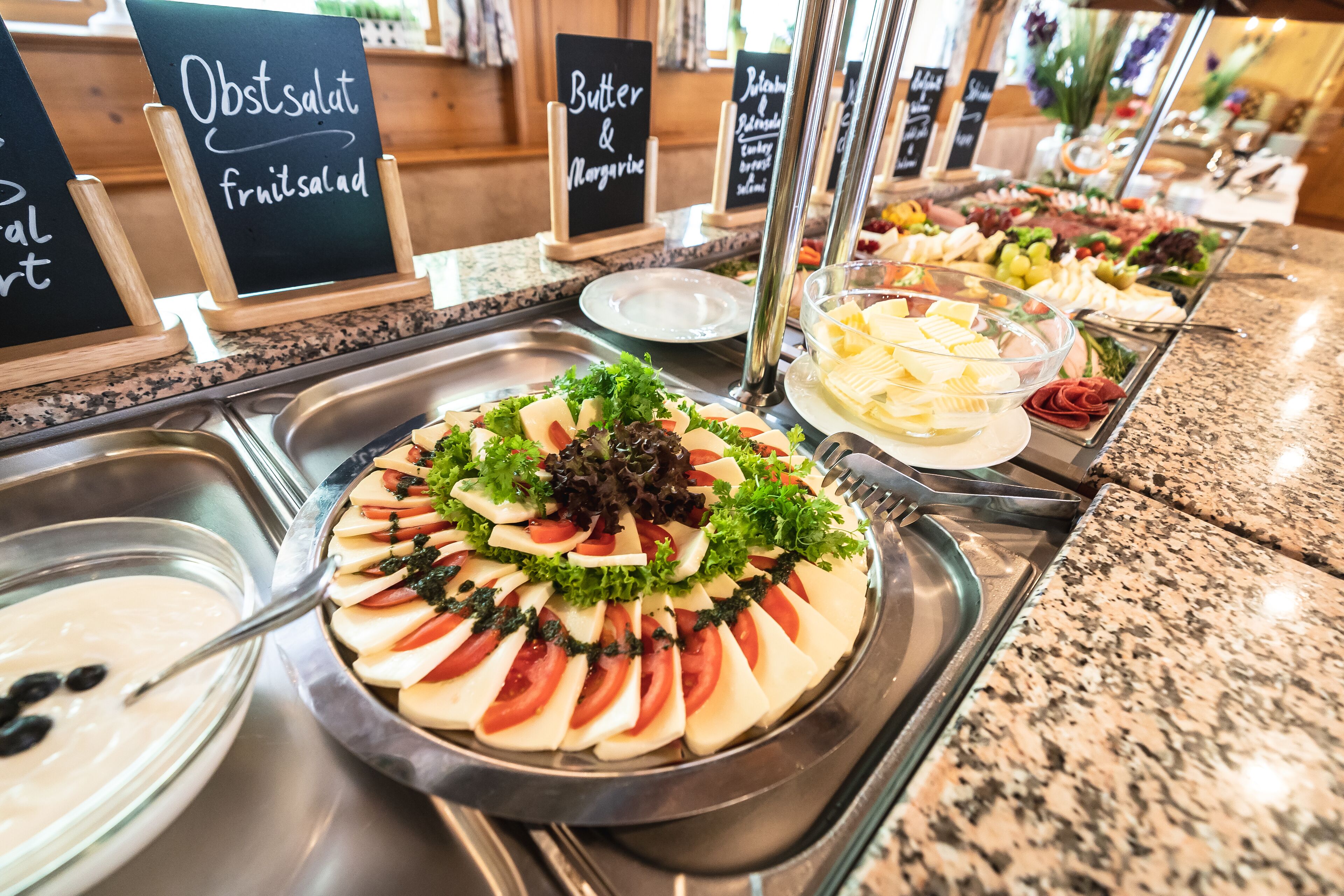A buffet with various food options including fruits, vegetables, and cheese.