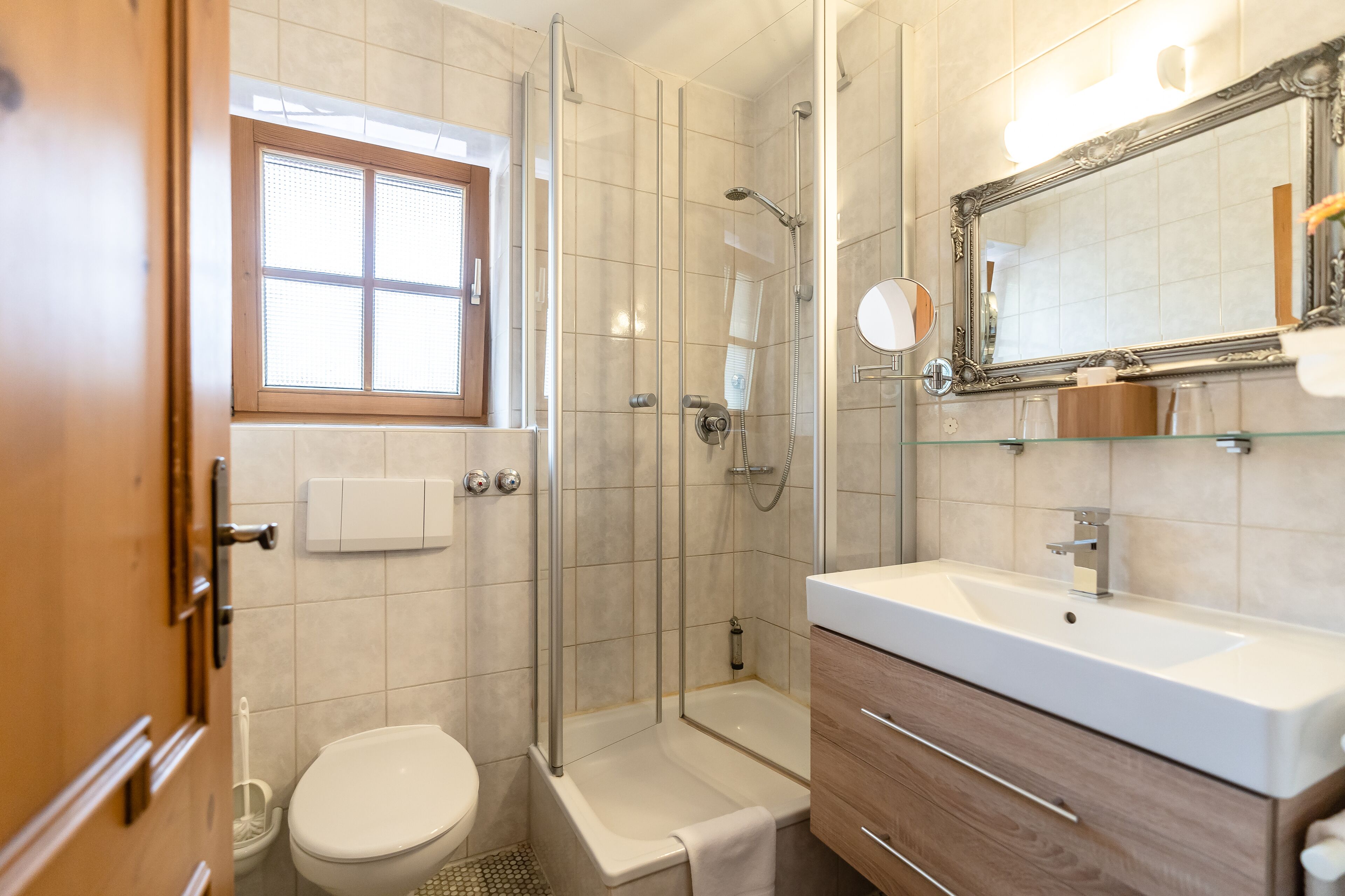 A bathroom with a toilet, shower, and sink.