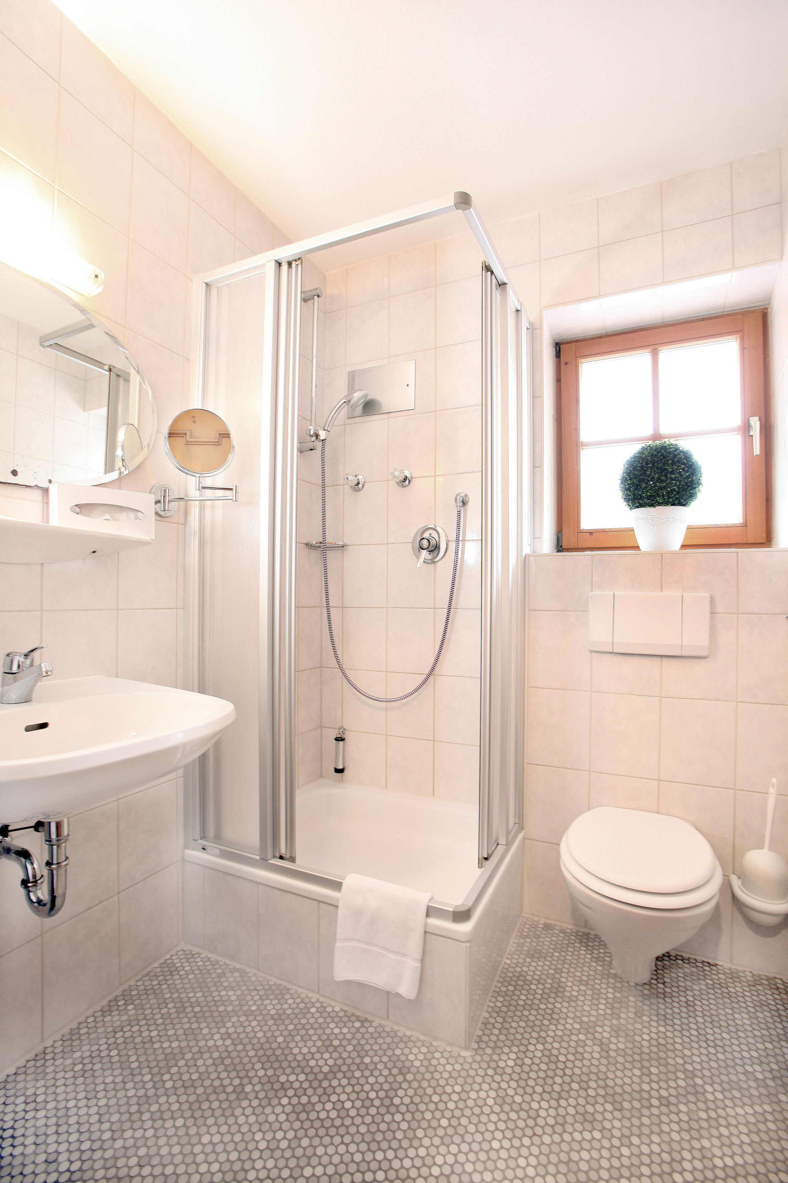 Ein Badezimmer mit Duschkabine, Waschbecken und Toilette.