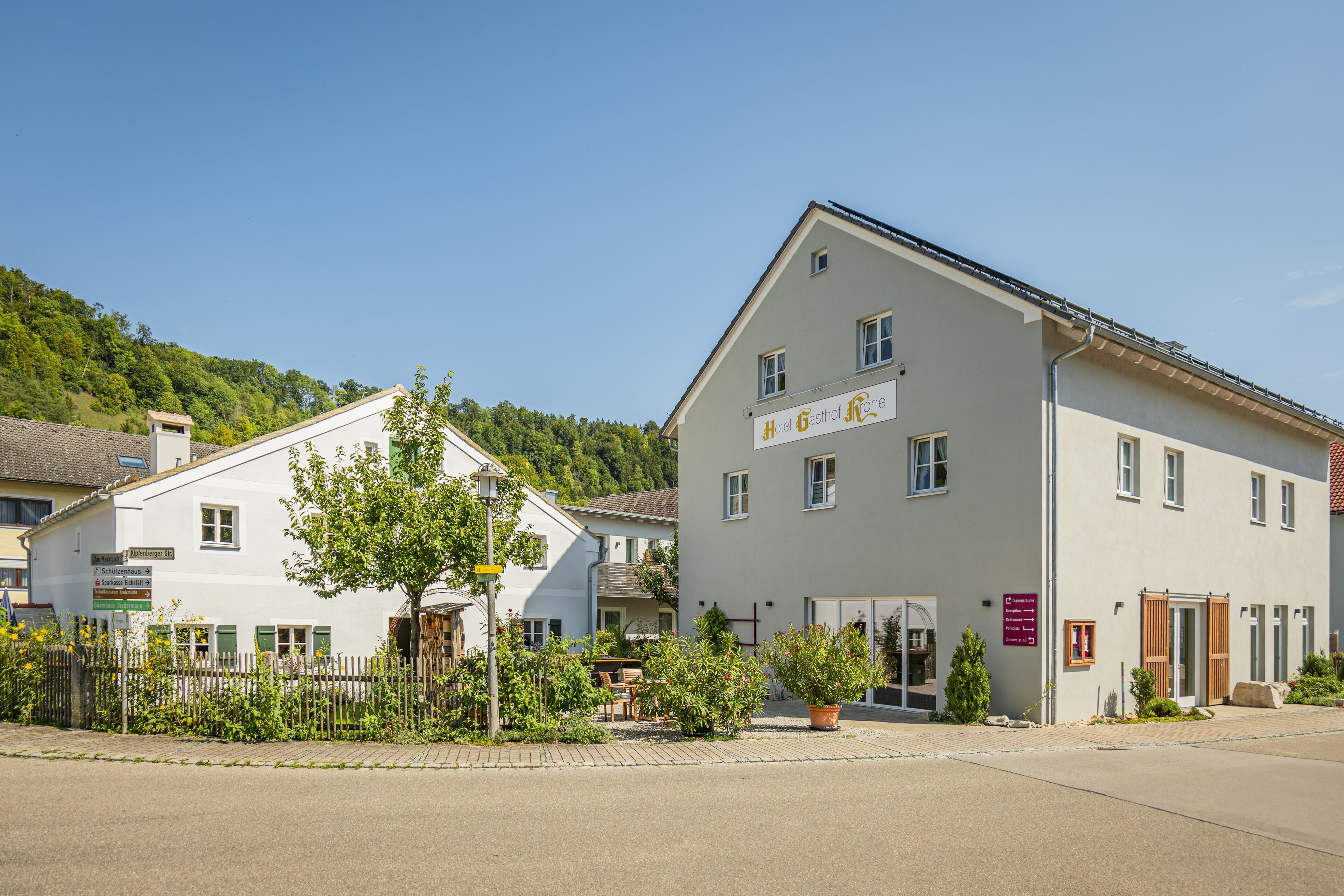 Ein zweistöckiges Gebäude mit einem Schild, auf dem 'Hotel Gasthof One' steht.
