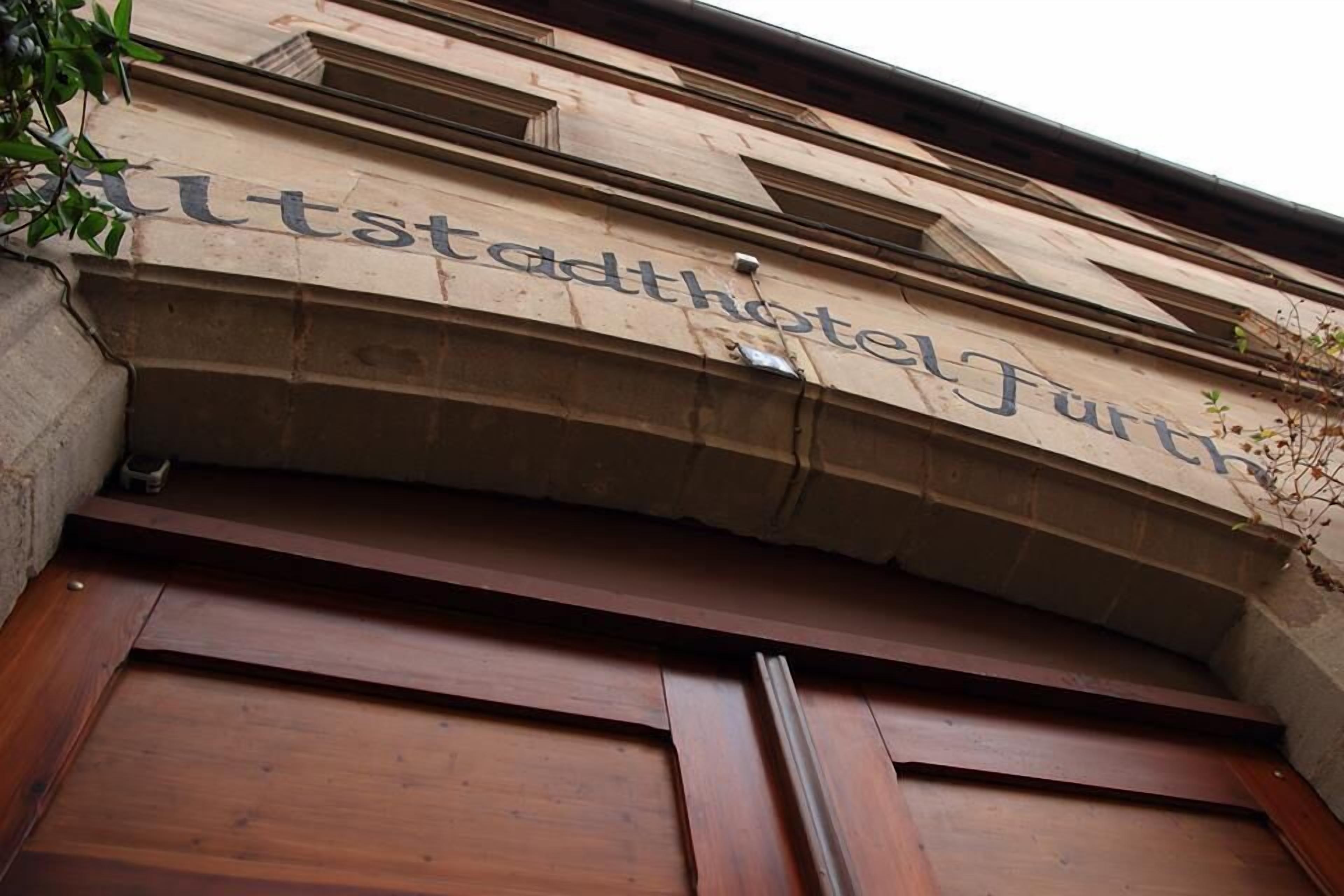 Fachada de un edificio con el nombre 'Stadthotel Furth' bien visible.