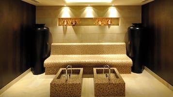 Une salle de bain moderne avec un banc, deux vasques et des vases décoratifs.