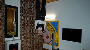 A living room with a fireplace, patterned wallpaper, a large painting, and a flat-screen TV. - HIP Hotel (Heidelberg)