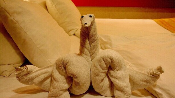 A bed with a unique dinosaur-shaped towel. - Hotel Toral (Santa Cruz de Mudela)