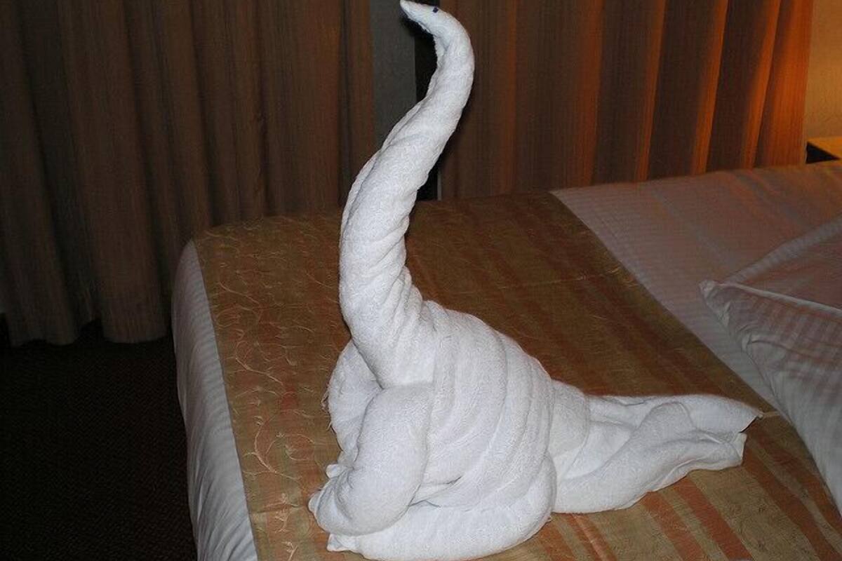 Una habitación de hotel con una cama cubierta con una toalla blanca.
