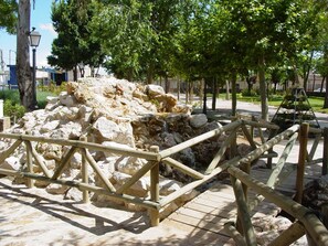 Una estructura de piedra con una valla de madera en un parque.