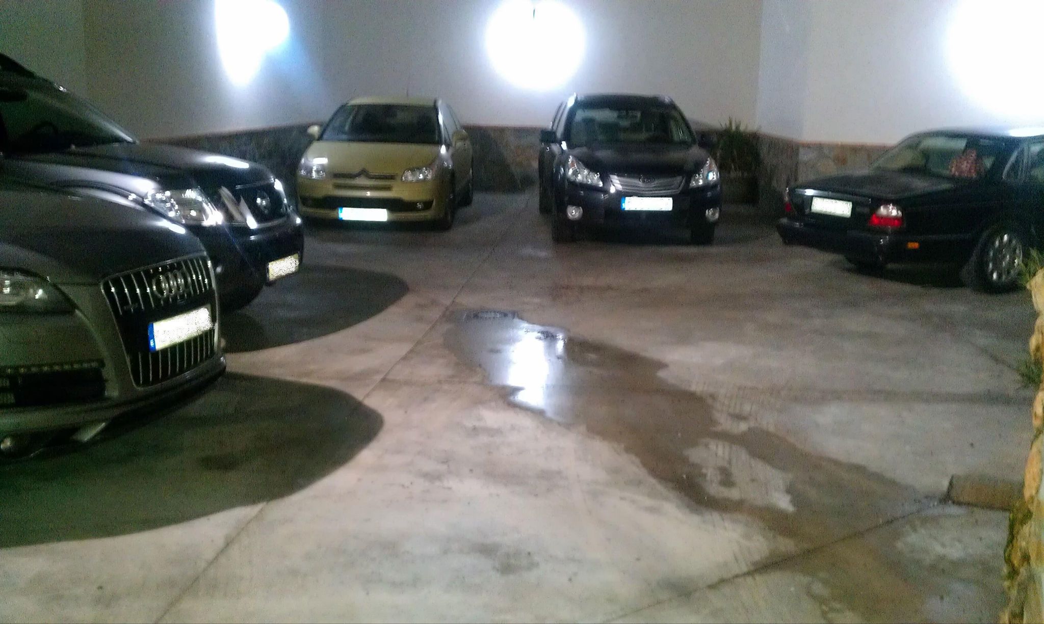 Un aparcamiento con varios coches estacionados.