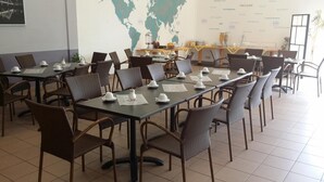 A dining area with tables set for service, chairs, and a world map on the wall. - Hotel Vicinity (Hoppstaedten-Weiersbach)