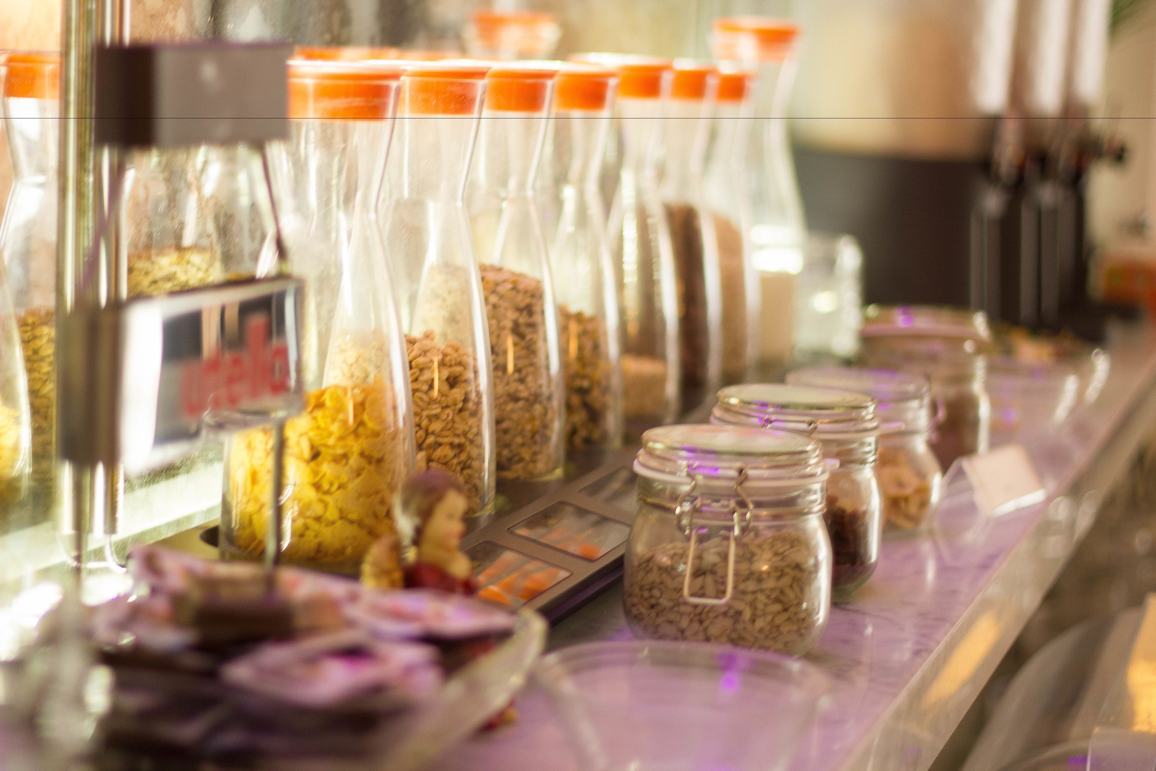 A variety of food items in glass jars with metal clasps, displayed on a counter.