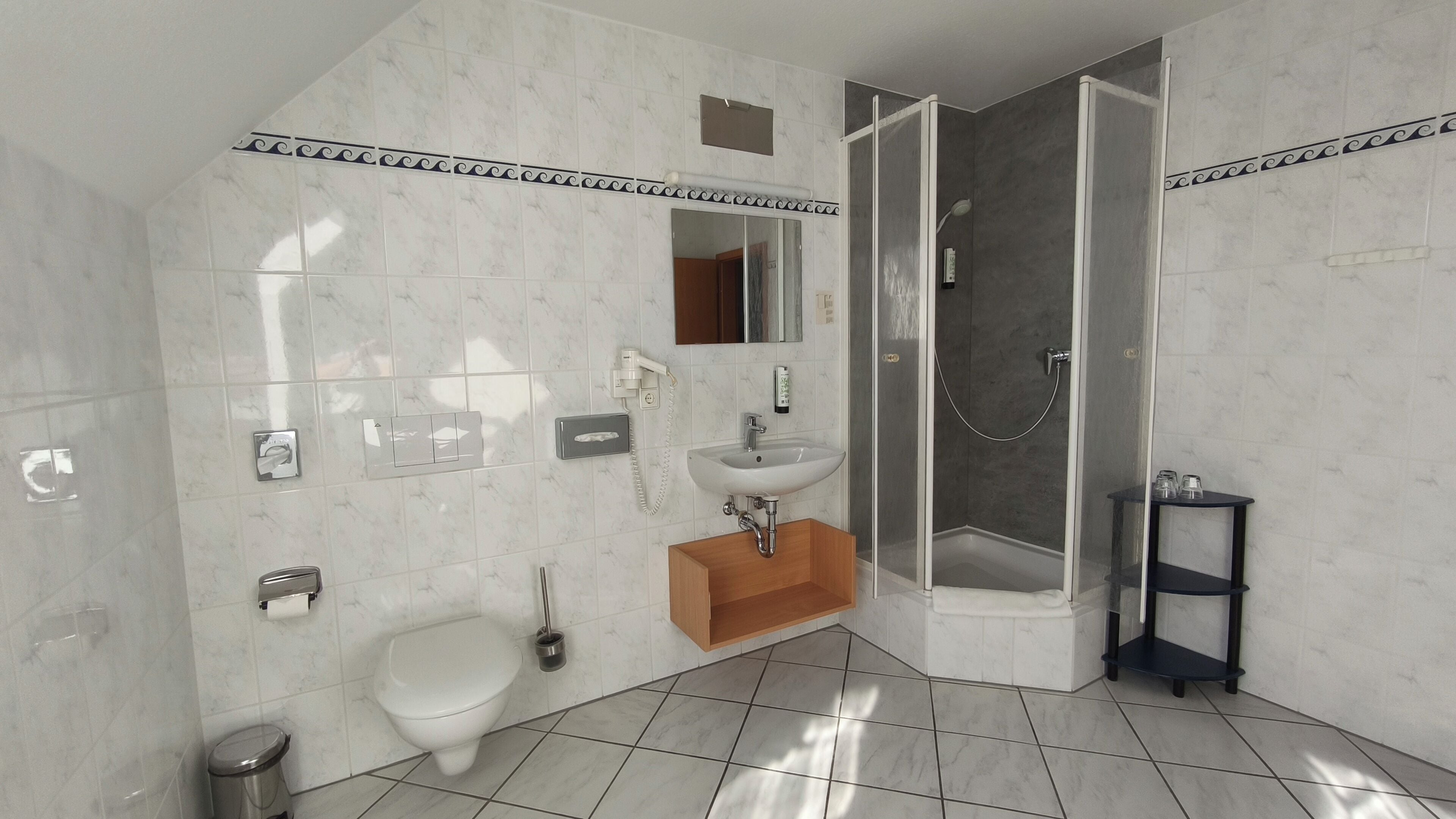 Une salle de bain comprenant des toilettes, un bidet, un lavabo et une douche.