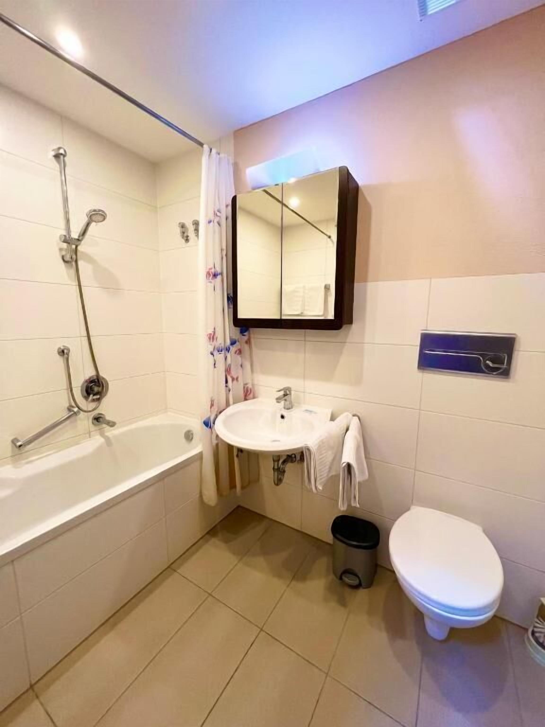 A bathroom with a bathtub, sink, and toilet.